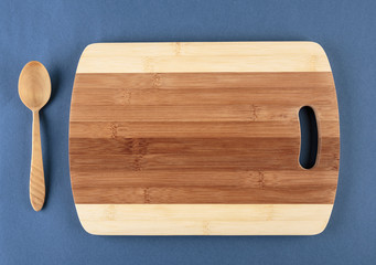 kitchen cutting board and a wooden spoon on a blue