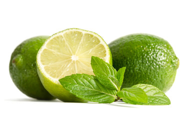 green mint, two limes with half of a juicy lime isolated on white background