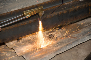 The technicians are using fire from a large steel cutter.