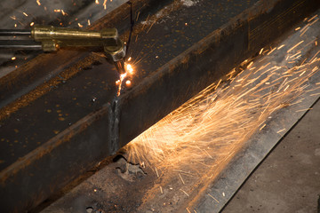 The technicians are using fire from a large steel cutter.