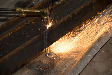 The technicians are using fire from a large steel cutter.