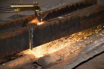 The technicians are using fire from a large steel cutter.