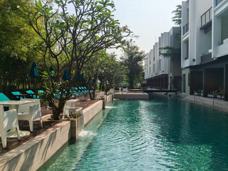 Swimming pool in a pool resort villa style hotel with modern interior architecture for concept of holiday / vacation in summer or tropical destination