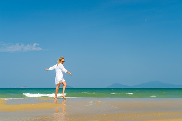Fototapeta na wymiar woman walking to the water on the beach