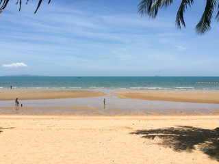 People walking in the sun on sea / ocean beach in hot summer day in Thailand