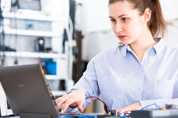 Young woman in electronics repair service center