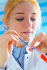 Laboratory assistant in the medical laboratory control a microbiological analysis of the blood. Using a pipette and a test tube in the laboratory