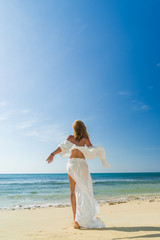 Fototapeta na wymiar woman walking to the water on the beach
