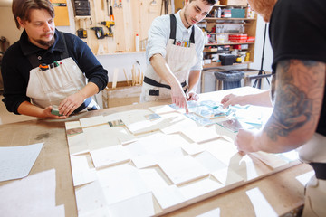 Craftsmans standing proudly in workshop alongside a wood and glass display case
