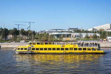 Fototapeta na wymiar Yellow cruise boat is sailing in front of Zaryadye park, Moscow, Russia