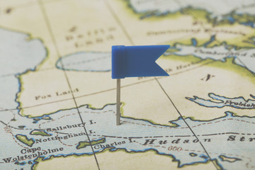 Fototapeta na wymiar Flag shaped push pin in a vintage travel map. travel destination planning concept