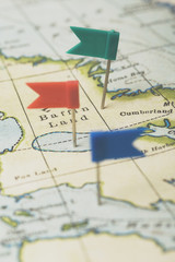 Flag shaped push pin in a vintage travel map. travel destination planning concept