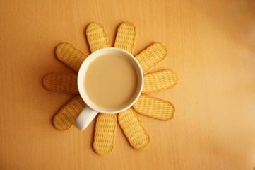 hot coffee with milk and sweet biscuits for breakfast in warm yellow and brown tones
