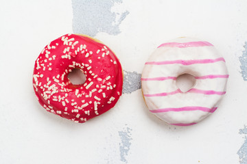 Sweet pink and white donuts on white background. Copy space