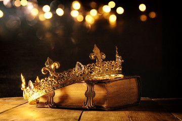 low key of queen/king crown on old book. vintage filtered. fantasy medieval period
