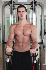 Fototapeta na wymiar Young attractive adult man exercising and doing weight lifting at fitness gym. Sport training indoors.