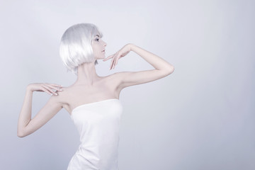 Obraz premium Young woman / female / girl with white wig / hair and white makeup posing as statue