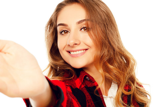 Portrait of a beautiful young woman making selfie on smart phone. Happy young woman photographing herself.