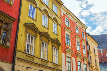 Colorful old buildings in Krakow city center, houses with red, orange and yellow walls