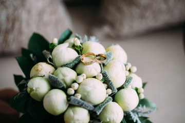 White bride's bouquet. Wedding rings closeup