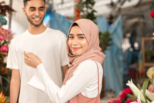 Muslim girl in flower shop looking in camera