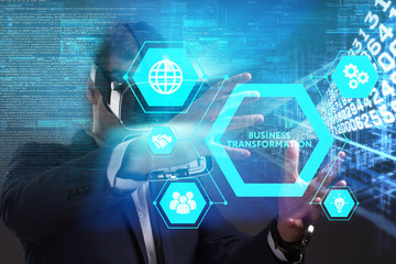 Business, Technology, Internet and network concept. Young businessman working in virtual reality glasses sees the inscription: Business transformation