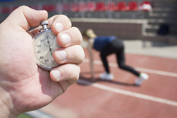 the hand with the stopwatch and the girl on the treadmill