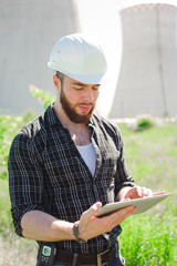 Smiling engineer using a tablet in a facility