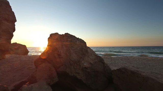Sun flares over cliffs of sea coast