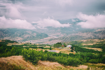 Fototapeta na wymiar View of mountains Babadag in the clouds and a river Girdimanchay Lahij yolu from the side in Lahic village, Azerbaijan