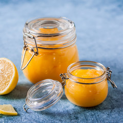 Lemon Curd in Jars over Blue Background