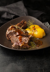 Grilled beef bone with sauce and baked vegetables on a plate