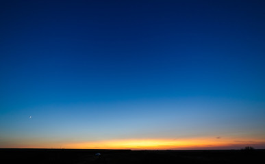 Fototapeta na wymiar Blue sky over a field at sunset.
