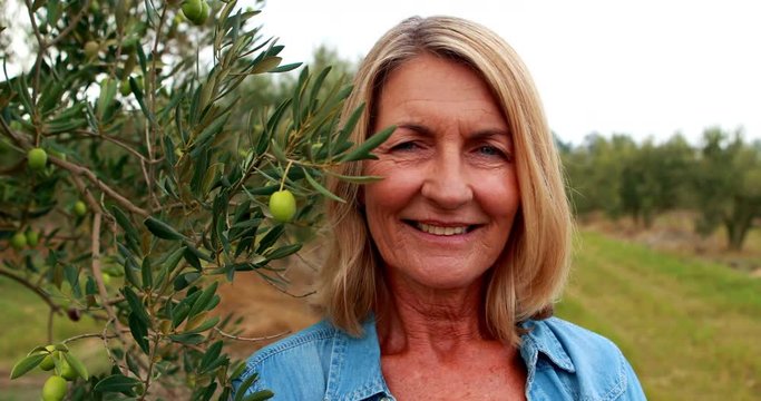 Portrait of happy woman standing in olive farm 