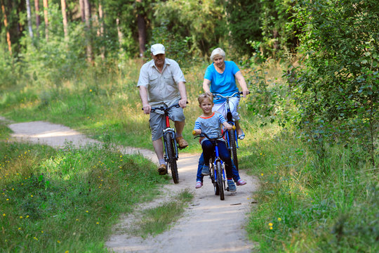 active senior couple with kids riding bikes in nature