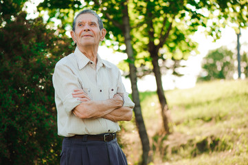 80 year old man posing in the summer park