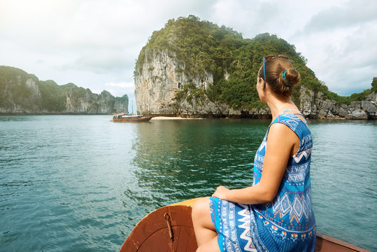 woman in dress is traveling by boat among the islands in Halong Bay. Vietnam.