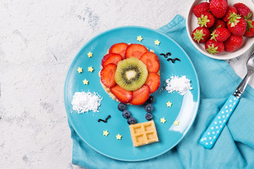 Sweet waffles with fruits in a shape of air balloon in the sky, meal for kids idea, top view © pavkis