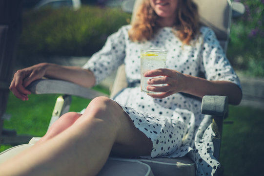 Woman drinking from glass in deck chair