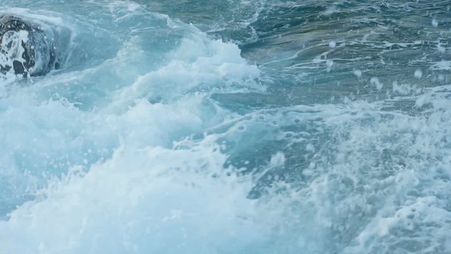 Sea waves crashing on stone beach - slow motion.
Close-up shot.
