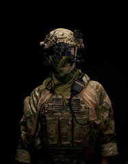 Soldier in military uniform with night vision goggles on background of dark wall 16