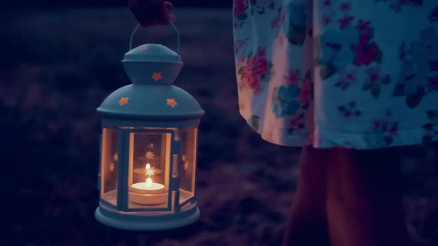 slow motion shot of a young woman with lantern exploring in nature