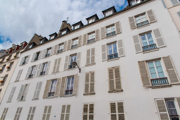 Fototapeta na wymiar Paris, attractive facades in Saint-Germain-des-Pres, with geometry of the windows, charming typical building 