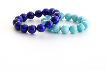Beautiful high grade royal blue Lapis lazuli and light-blue Larimar or Stefilia's Stone beads in bracelets on white background
