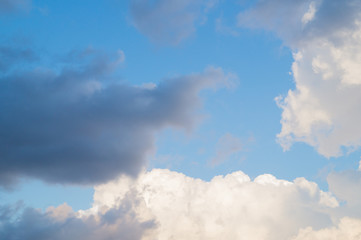 Grey and white fkuffy clouds on the light-blue sky