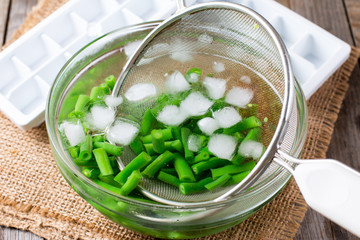 Boiled vegetables, green beans  in ice water after blanching