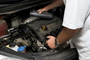 The mechanic fixes the vehicle's engine