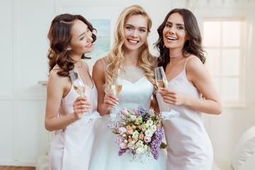 bride with bridesmaids drinking champagne - obrazy, fototapety, plakaty