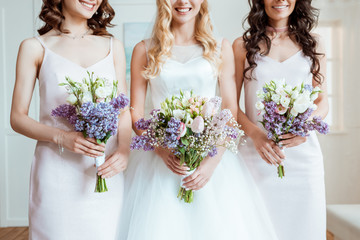 bride with bridesmaids holding bouquets - obrazy, fototapety, plakaty