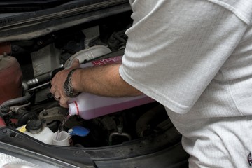 The mechanic fixes the vehicle's engine